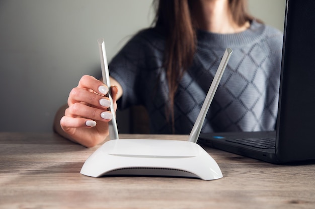 Frau, die im Computer mit WLAN-Router arbeitet