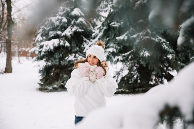 Foto frau, die im park mit weihnachtslichtern aufwirft. winterferien-konzept.