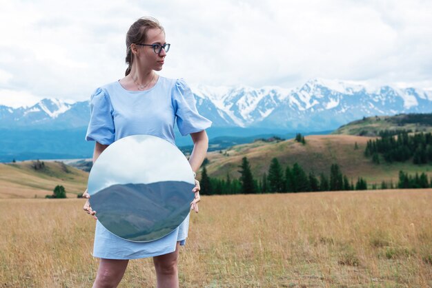 Frau, die im Sommer Altai-Berge in der Kurai-Steppe steht und Kreisspiegel kreative Reise hält ...