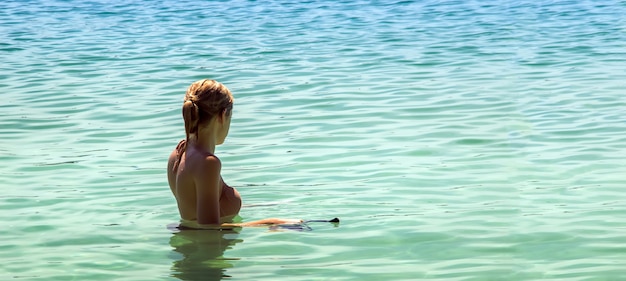 Frau, die im Sommer am Strand schnorchelt