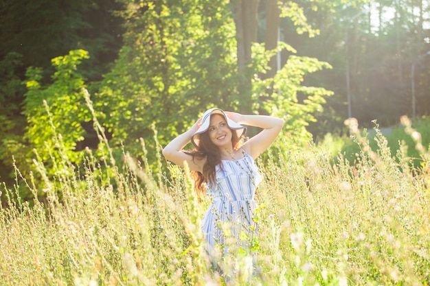 Frau, die im sonnigen Sommertag auf einem Feld geht