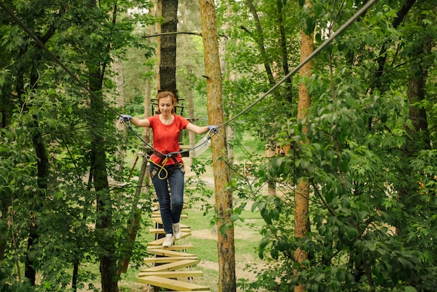 Frau, die im Waldabenteuerseilpark klettert