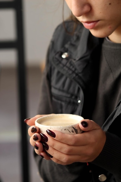 Foto frau, die im winter eleganten kaffee oder tee trinkt