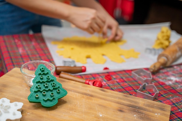 Frau, die im Winterurlaub zu Hause Lebkuchen kocht. Hausgemachte Weihnachtsplätzchen für Weihnachten und ein glückliches neues Jahr.