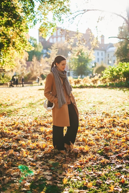 Frau, die in den Herbstpark geht