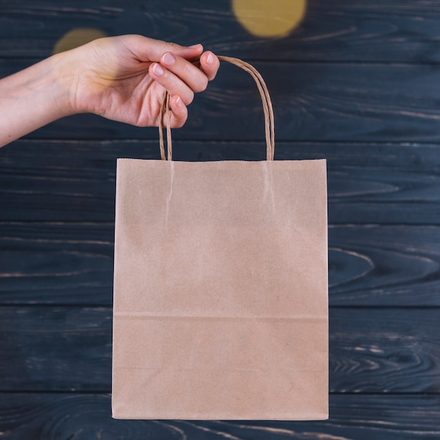 Foto frau, die in der hand geschenktasche hält