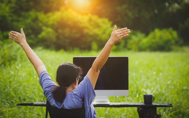 Frau, die in einem Außenbüro mitten in der Natur arbeitet. CSR-Konzept