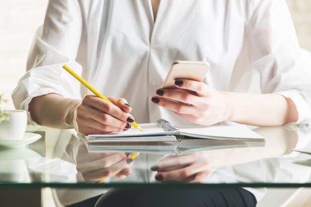 Frau, die Informationen vom Telefon kopiert