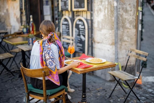 Frau, die italienische Pasta im Restaurant auf der Straße in Rom isst