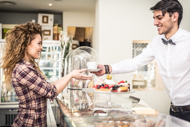 Frau, die Kaffee an der Bar nimmt