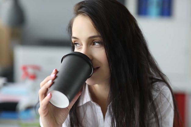 Frau, die Kaffee im Büro genießt