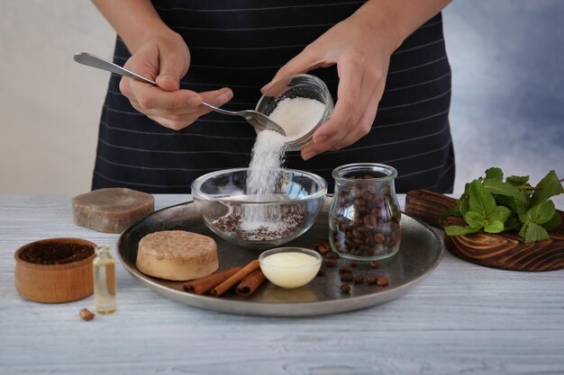 Frau, die Kaffee-Körperpeeling auf Holztisch macht