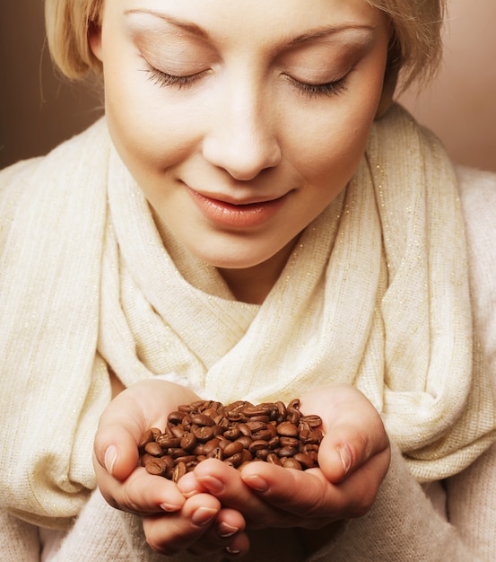 Frau, die Kaffeebohnen hält.