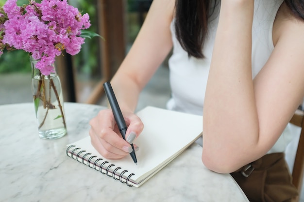 Foto frau, die kenntnis mit schwarzem stift nimmt