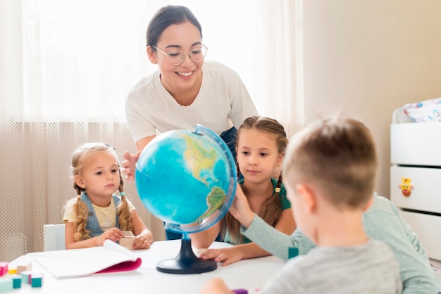 Foto frau, die kinder geographie lehrt