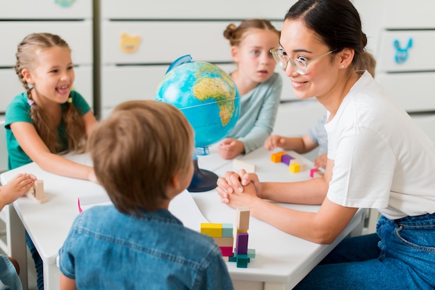 Foto frau, die kindern geographie lehrt