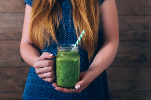 Frau, die Kiwi Smoothie hält