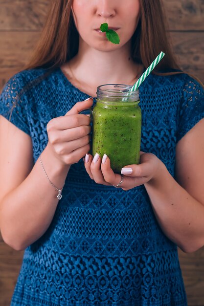 Frau, die Kiwi Smoothie hält