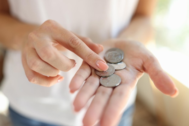 Frau, die kleine münzen in ihren händen zählt, nahaufnahme, günstiger preis, geld und armutskonzept