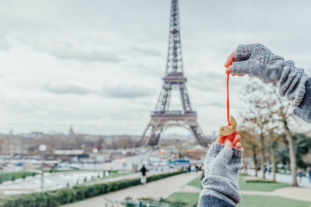 Frau, die kleinen Keramikvogel auf dem Eiffelturm in Paris, Frankreich hält