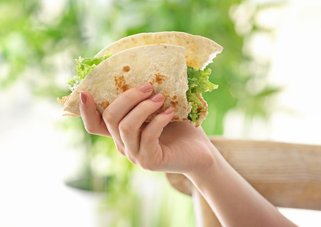 Frau, die köstlichen Fischtaco in der Küche hält