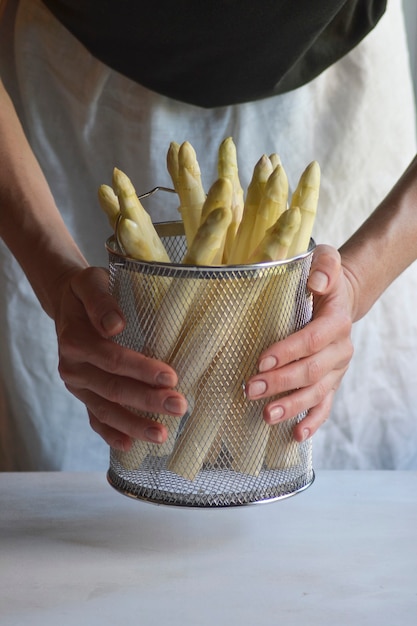 Frau, die Korb mit weißem Spargel hält