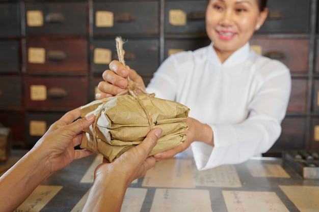 Frau, die Kräuter in der Apotheke verkauft