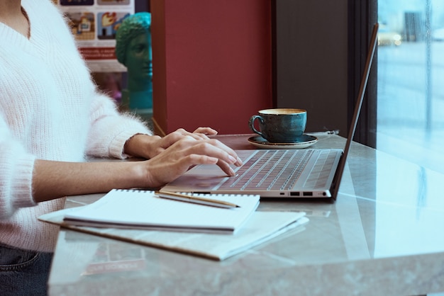 Frau, die Laptop auf Arbeitsplatzabschluß aufbraucht