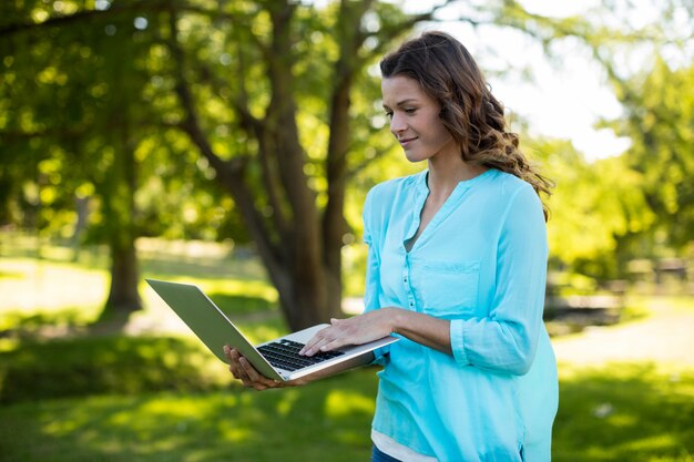 Frau, die Laptop im Park benutzt