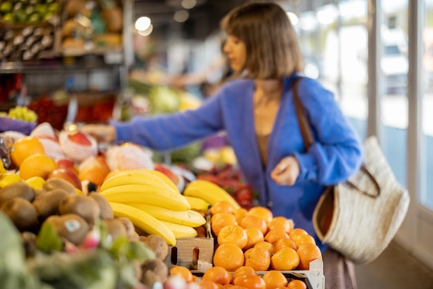 Frau, die Lebensmittel am Markt einkauft