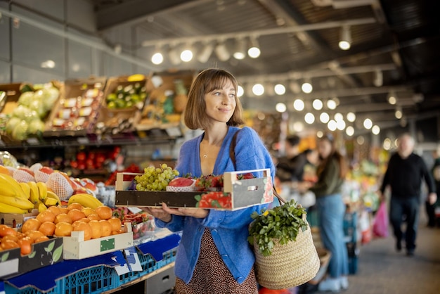 Frau, die Lebensmittel am Markt einkauft