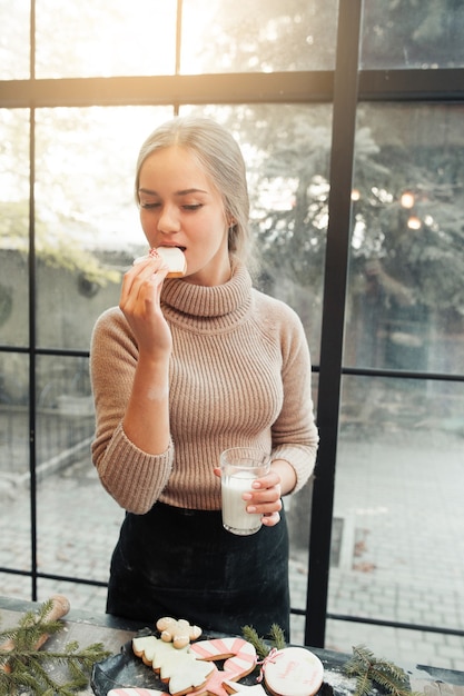 Frau, die Lebkuchenplätzchen mit Milch isst