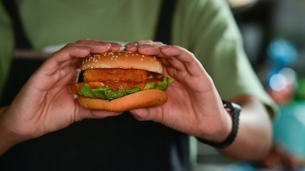 Frau, die leckeren hausgemachten fischburger hält