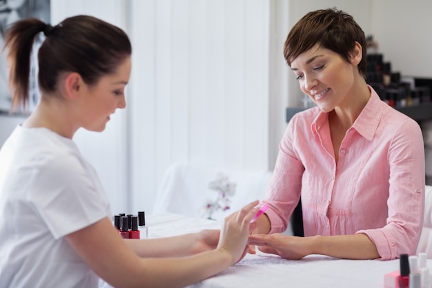 Frau, die Maniküre im Nagelsalon erhält