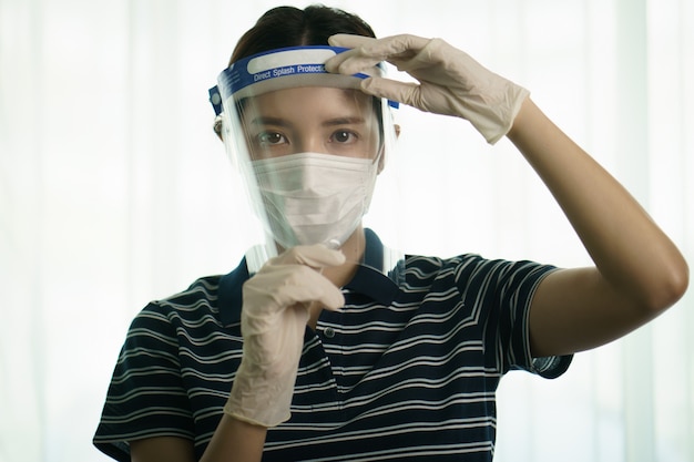 Frau, die medizinischen Schutzschirm oder Plastikschild auf ihrem Gesicht trägt, für Koronavirus oder Covid-19-Schutz.