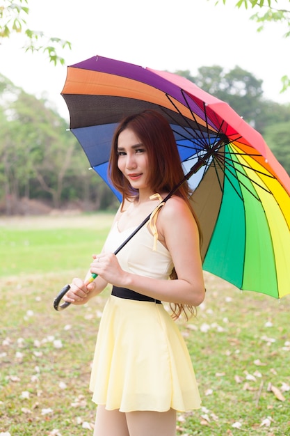 Frau, die mehrfarbigen Regenschirm hält