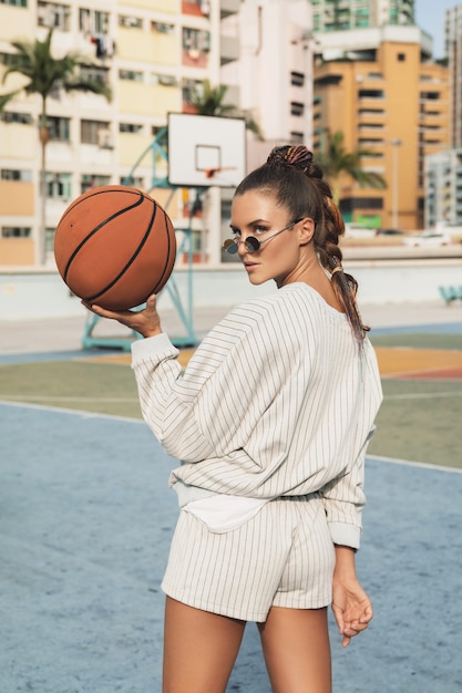 Frau, die mit Basketball auf Basketballplatz aufwirft