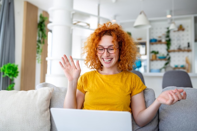 Frau, die mit Computer auf Sofa sitzt und zu Hause E-Learning und freiberufliches Jobkonzept lernt