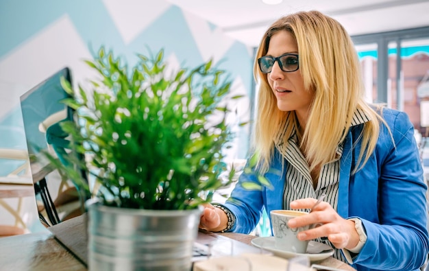 Frau, die mit dem Laptop in einem Café arbeitet