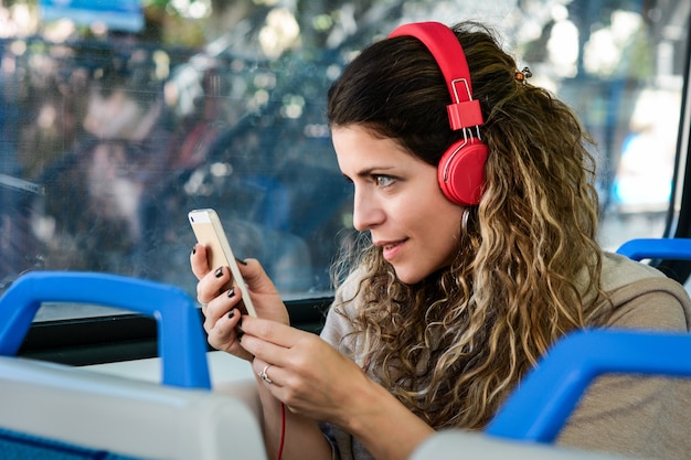 Frau, die mit dem Zug unter Verwendung des Smartphone reist.