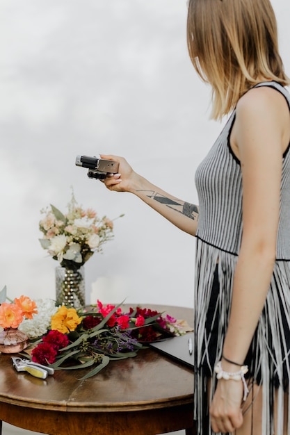 Frau, die mit einer Kamera ein Foto von bunten Blumen macht