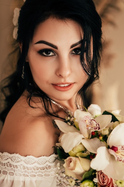 Frau, die mit Hochzeitsblumenstrauß sitzt
