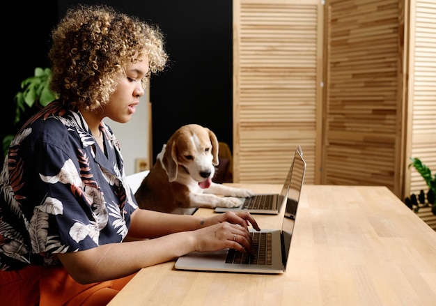 Frau, die mit ihrem Begleiter am Laptop arbeitet