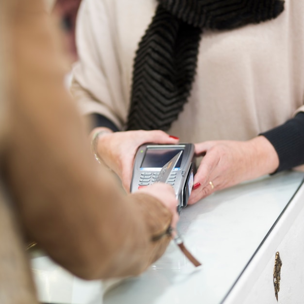 Frau, die mit Kreditkarte durch Anschluss zahlt