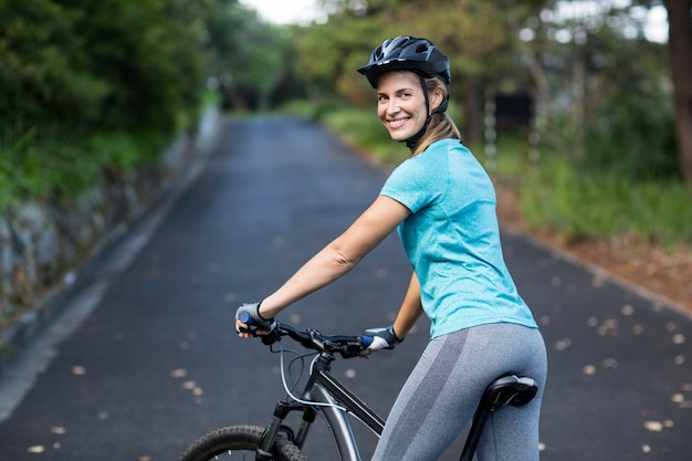 Frau, die mit Mountainbike auf der offenen Straße steht