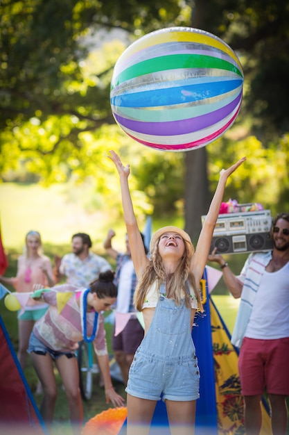 Frau, die mit Strandball am Campingplatz spielt