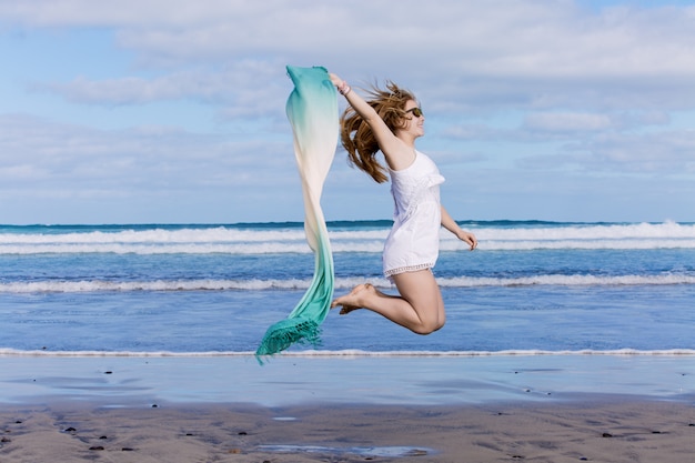 Frau, die mit Strandverpackung springt