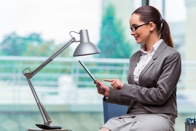 Frau, die mit Tablette im Büro arbeitet