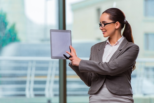 Frau, die mit Tablette im Büro arbeitet