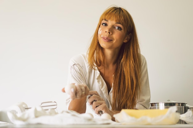 Frau, die mit Teigvorbereitungsrezeptbrotpizza oder -kuchen arbeitet, die Zutaten kochen, die Kuchen kochen